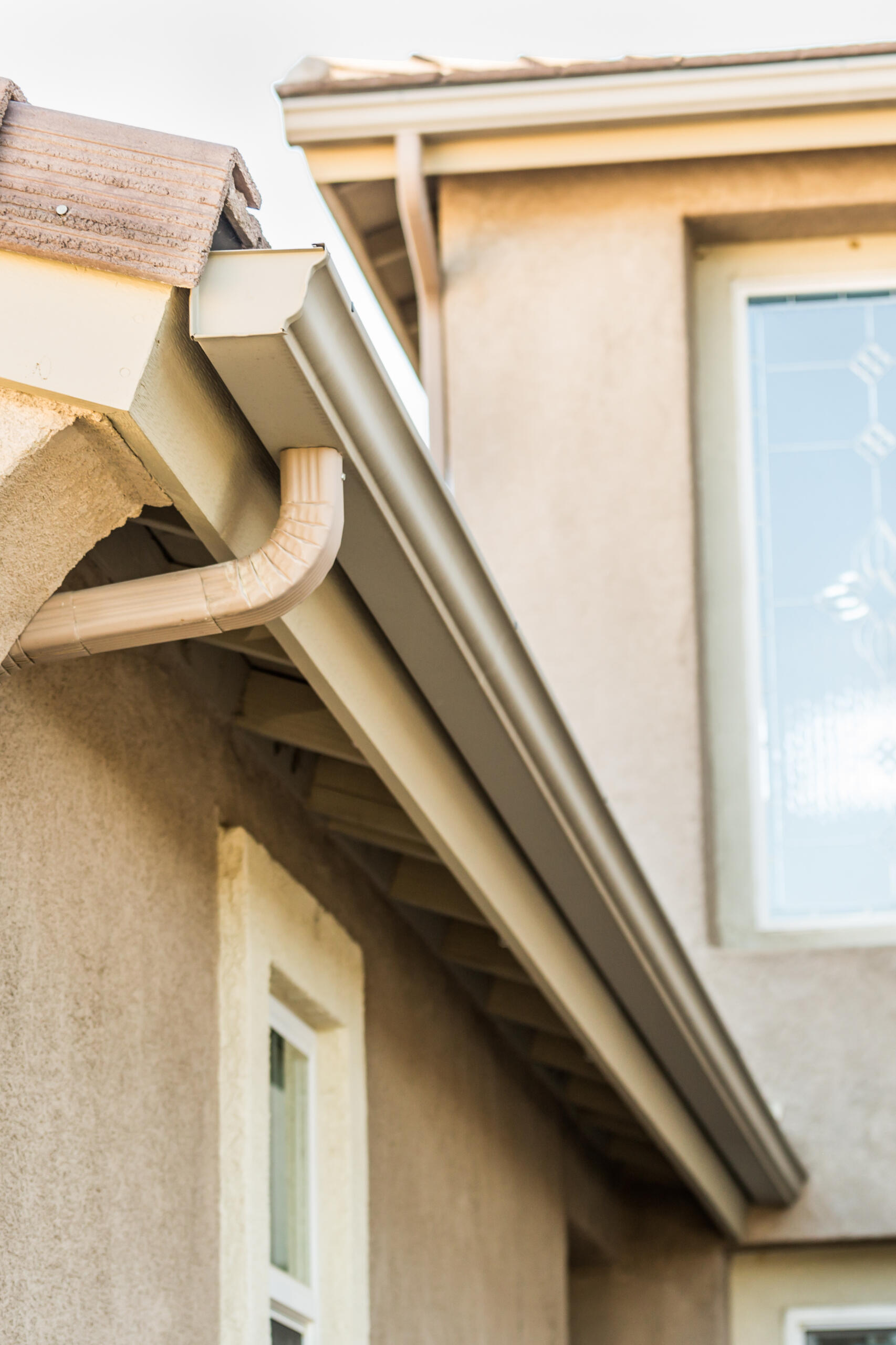 Professional installing seamless gutters on a residential home in Albuquerque. Completed.