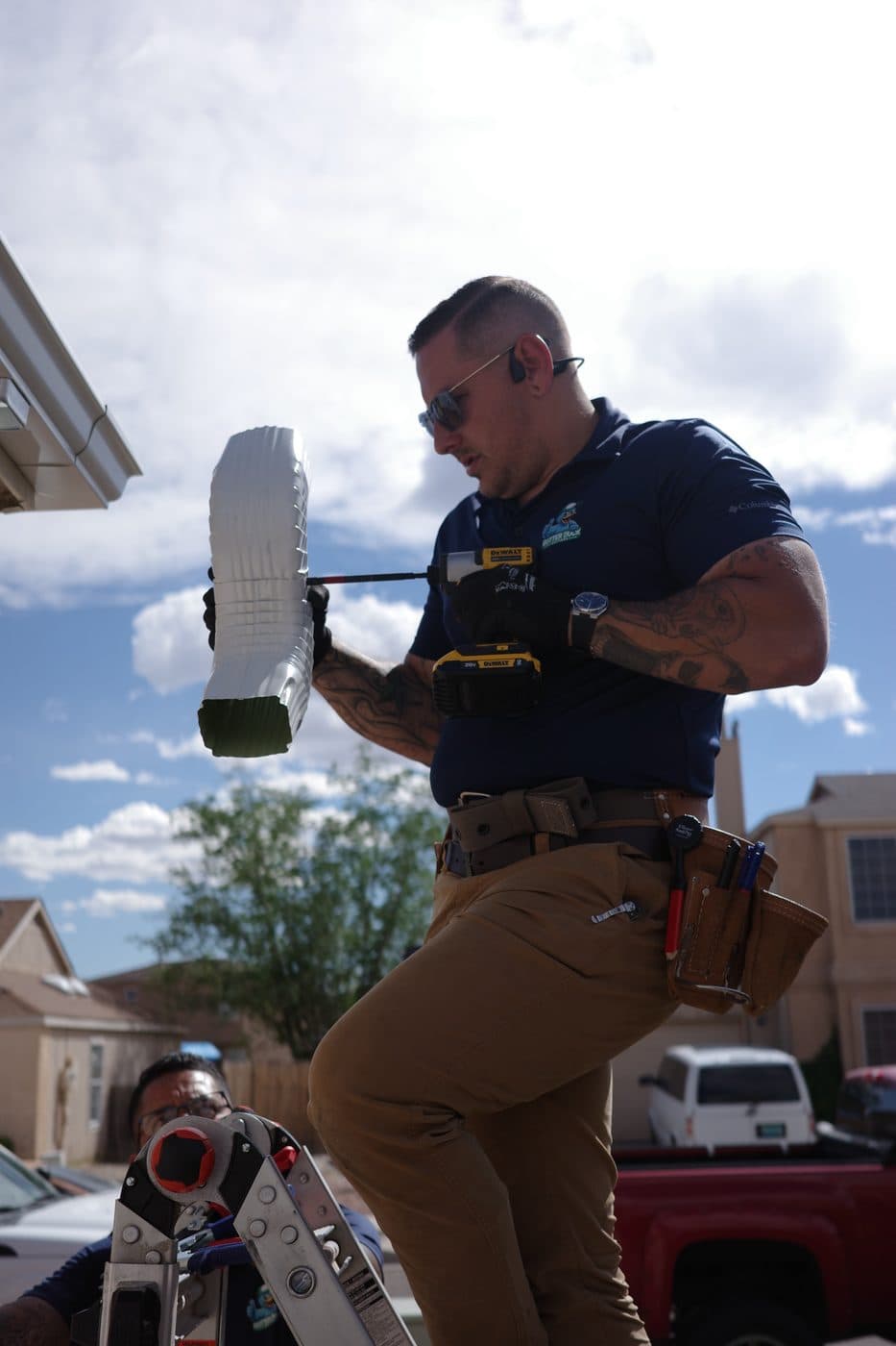 Technician inspecting a freshly formed seamless gutter section