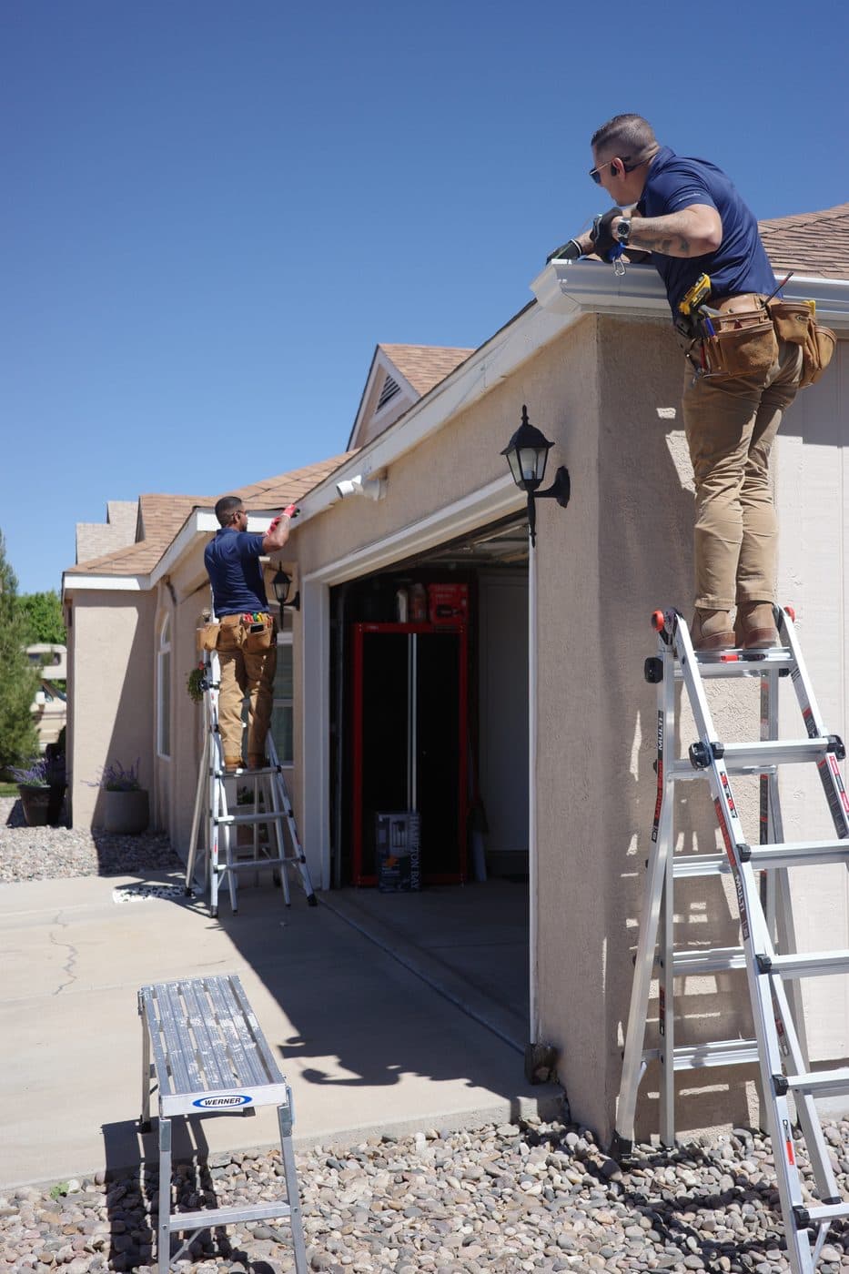 Gutter Duck Gutters team installing new gutters from ladders on an Albuquerque home